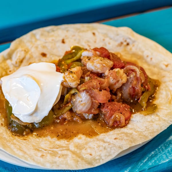 Gorditos' shrimp fajita taco with peppers, tomatoes, and a dollop of sour cream.