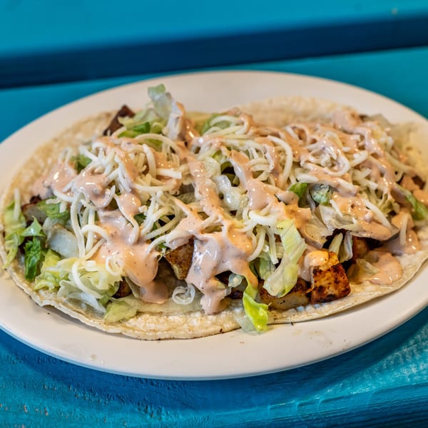 Gorditos Mexican restaurant's fish taco, topped with shredded lettuce, cheese, and creamy sauce.